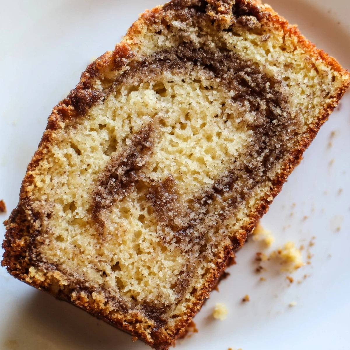Warm cinnamon sugar swirl banana bread with caramelized crust, ready to serve on wooden board