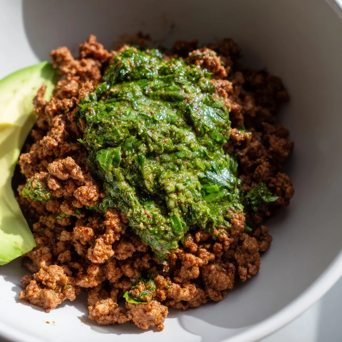 Seasoned Chimichurri ground beef bowls topped with fresh avocado slices and colorful crisp vegetables