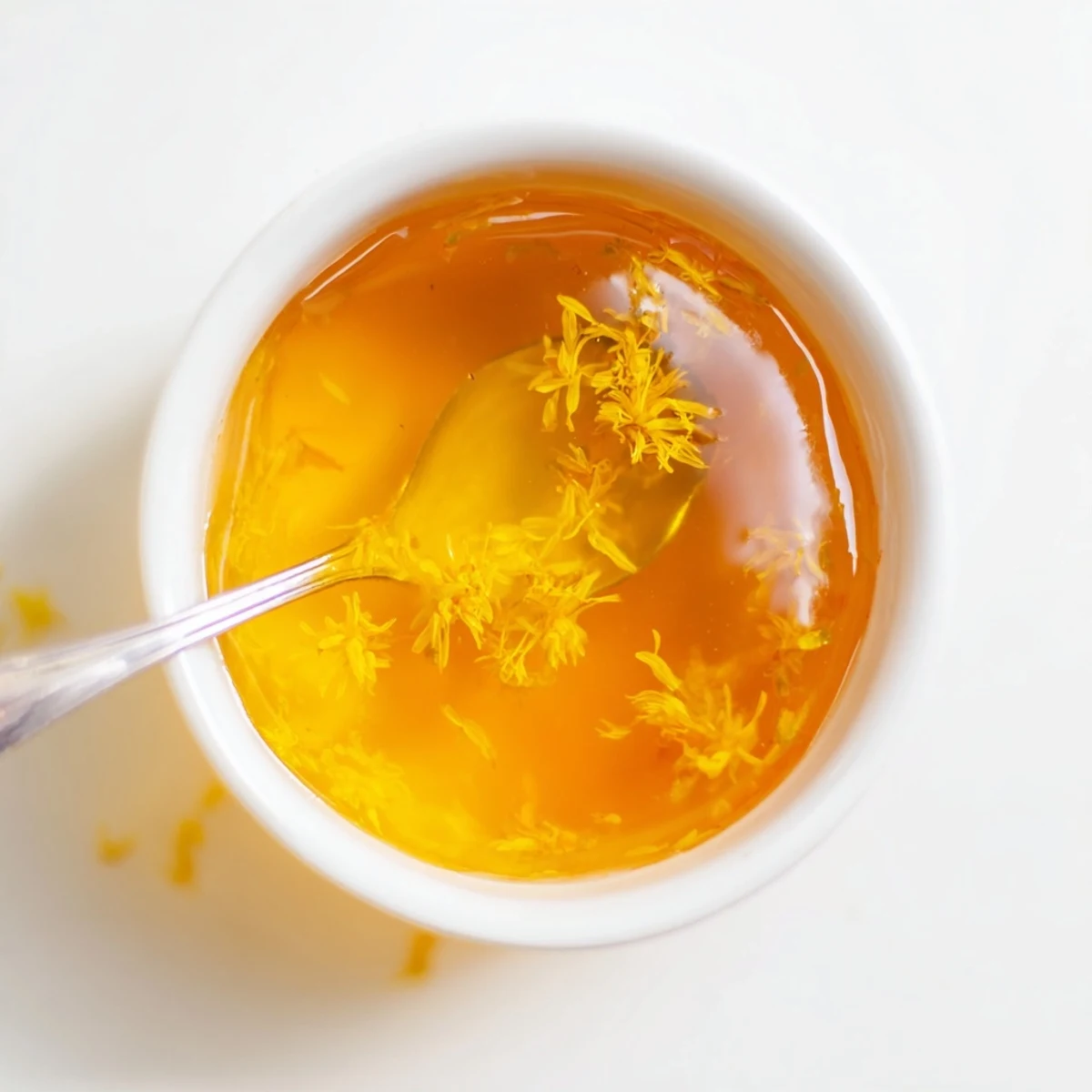 Golden homemade fresh dandelion jelly spooned onto a slice of warm toast