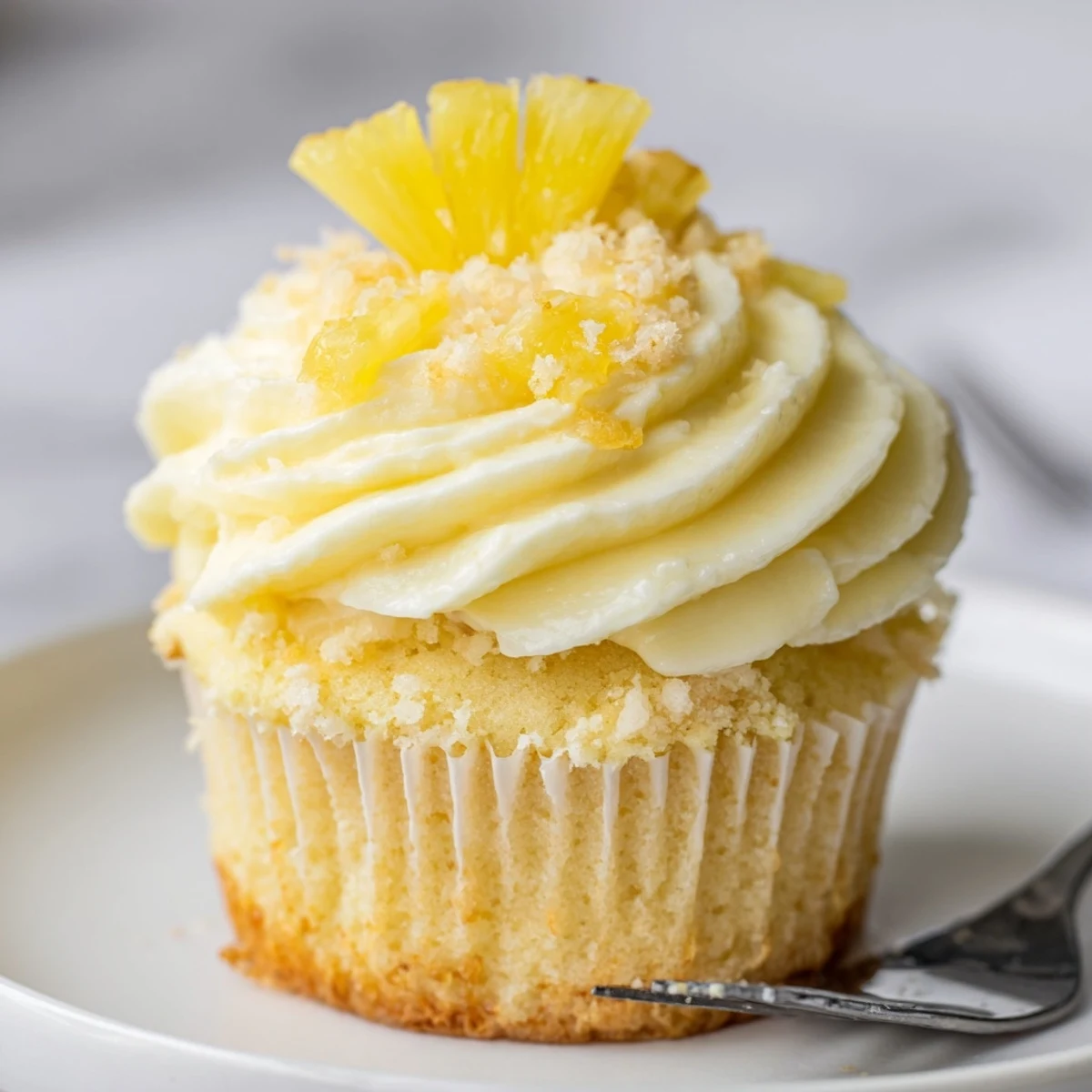 Dole Whip Cupcakes Recipe plated with fluffy pineapple frosting and maraschino cherry
