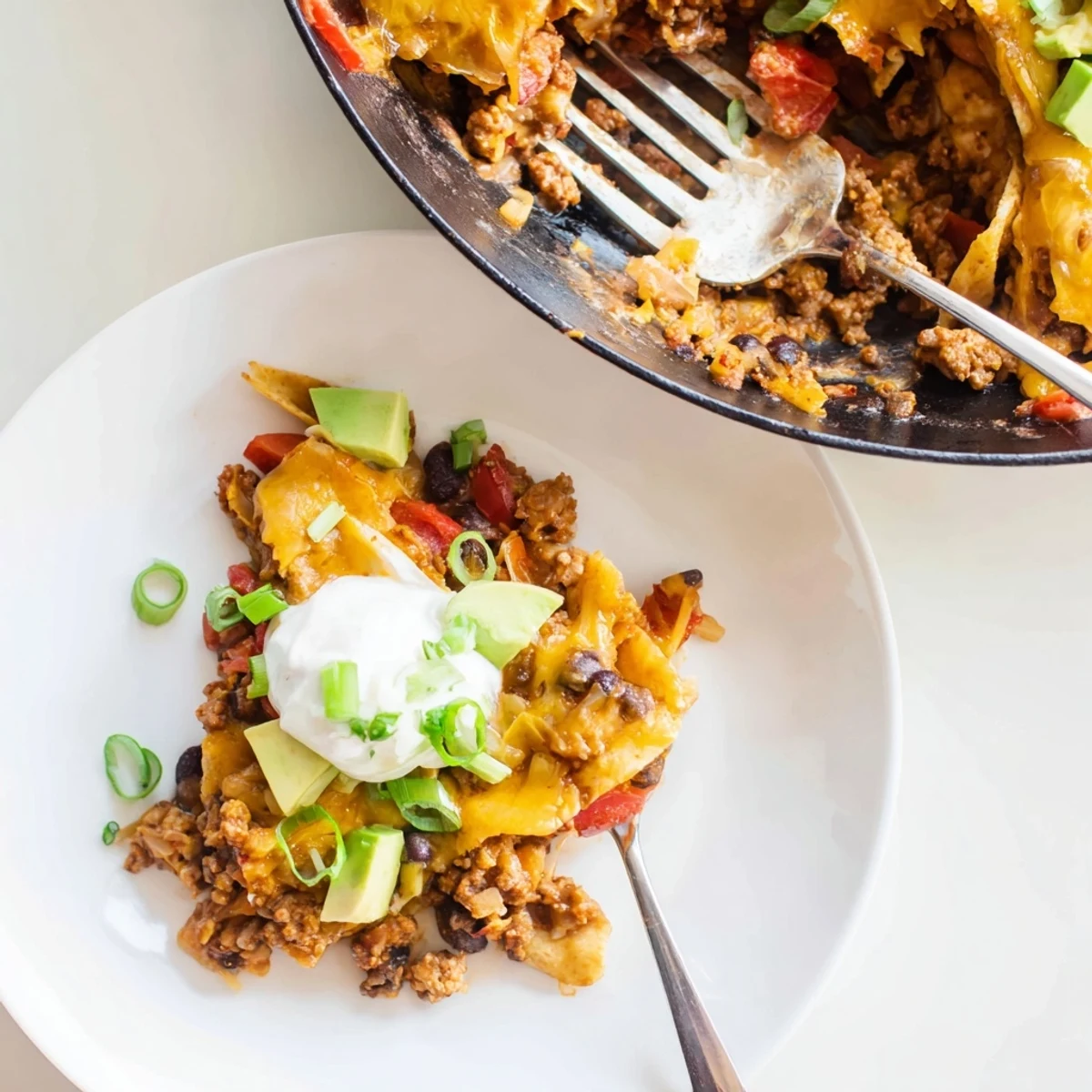 Beef Skillet Enchiladas bubbling in cast-iron skillet, melty cheese and cilantro