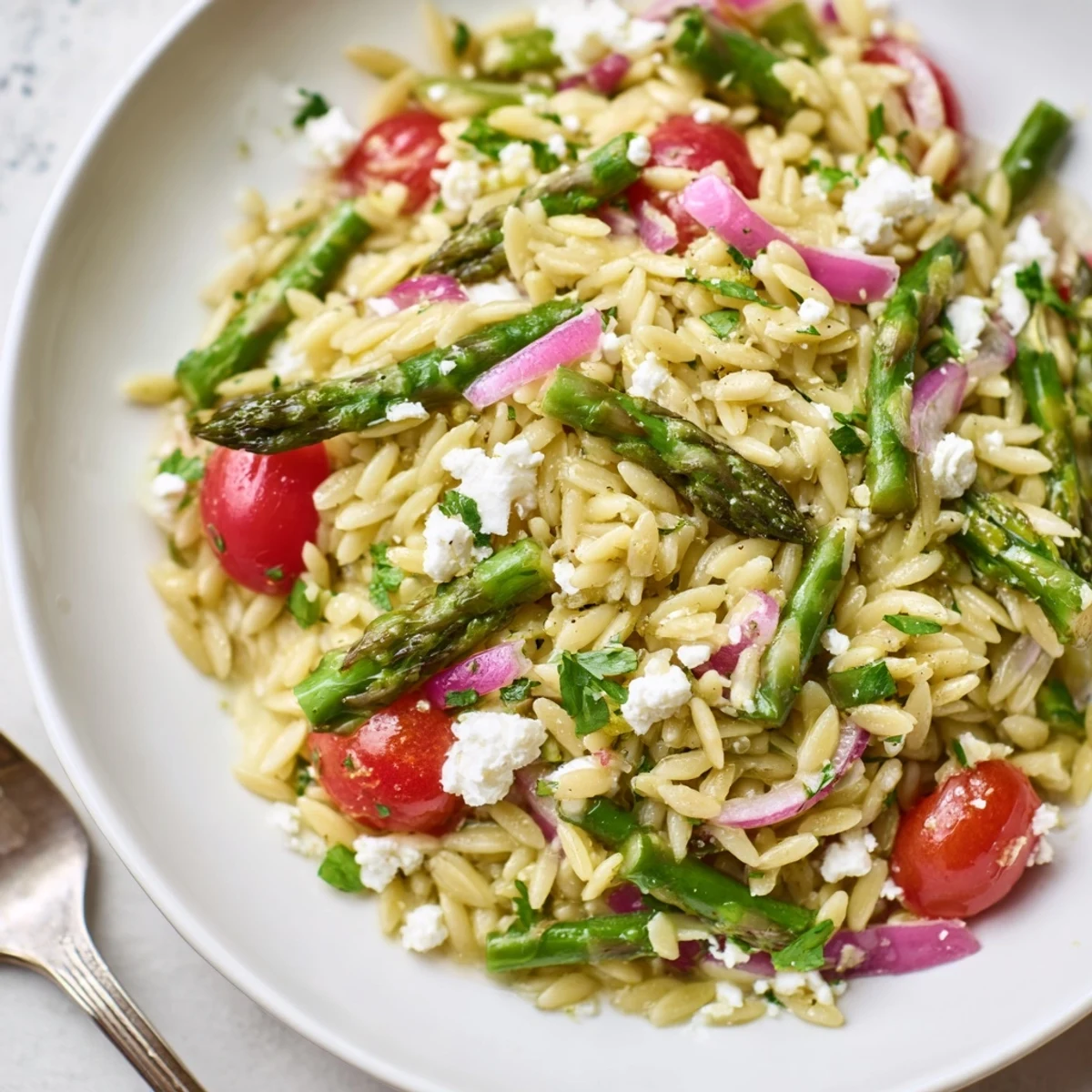 Bright Asparagus Orzo Salad With Lemon Vinaigrette tossed with cherry tomatoes and feta