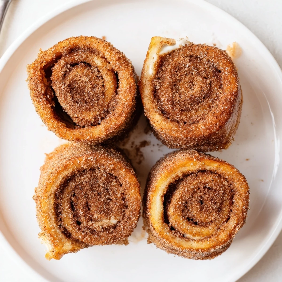 Cinnamon Roll French Toast Roll Ups served with warm maple syrup and powdered sugar