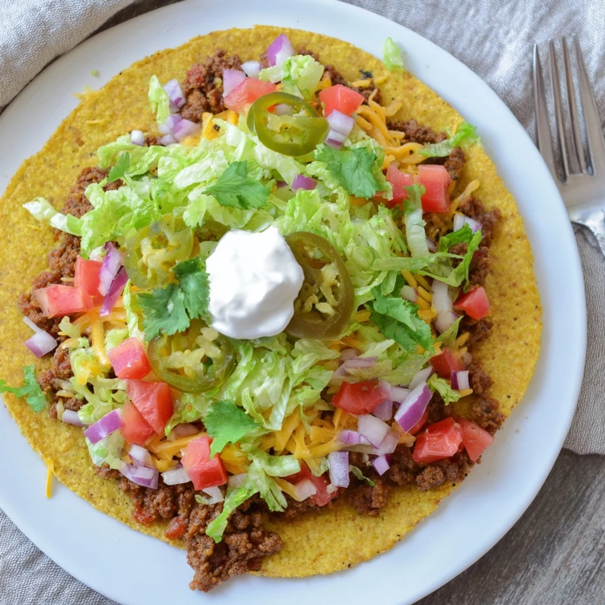 Golden brown crispy beef smash tacos loaded with melted cheddar and Monterey Jack cheese on a sizzling Blackstone griddle