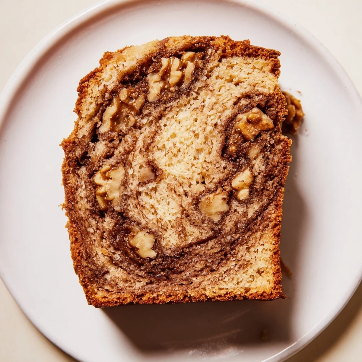 Warm banana nut bread with cinnamon swirl served on plate with melted butter pooling