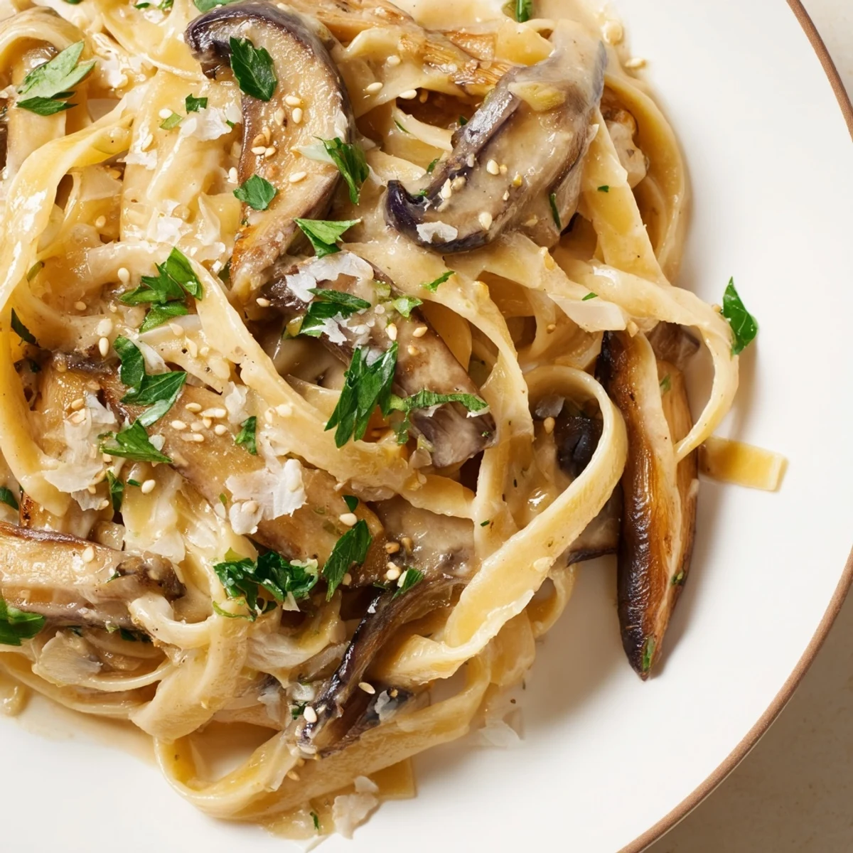 Steaming bowl of Japanese-Italian fusion pasta featuring savory mushroom slices and rich umami cream sauce