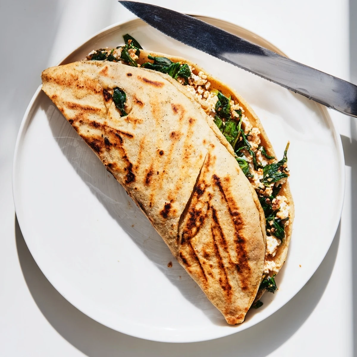 Golden brown Turkish Gozleme with spinach and feta filling, freshly cooked on a skillet