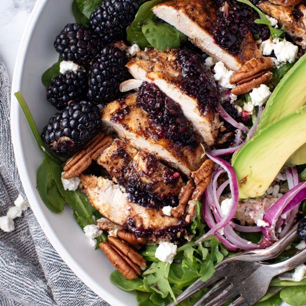 Sweet Tangy Blackberry Chicken Salad Recipe topped with sliced avocado and toasted pecans
