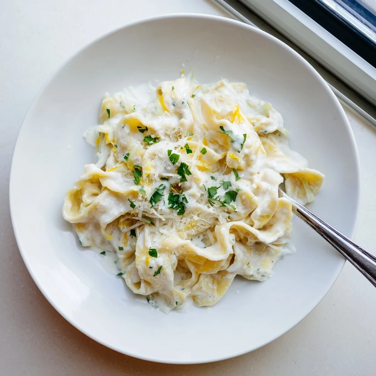 Creamy cafeteria noodles in white sauce topped with fresh parsley and grated Parmesan cheese.