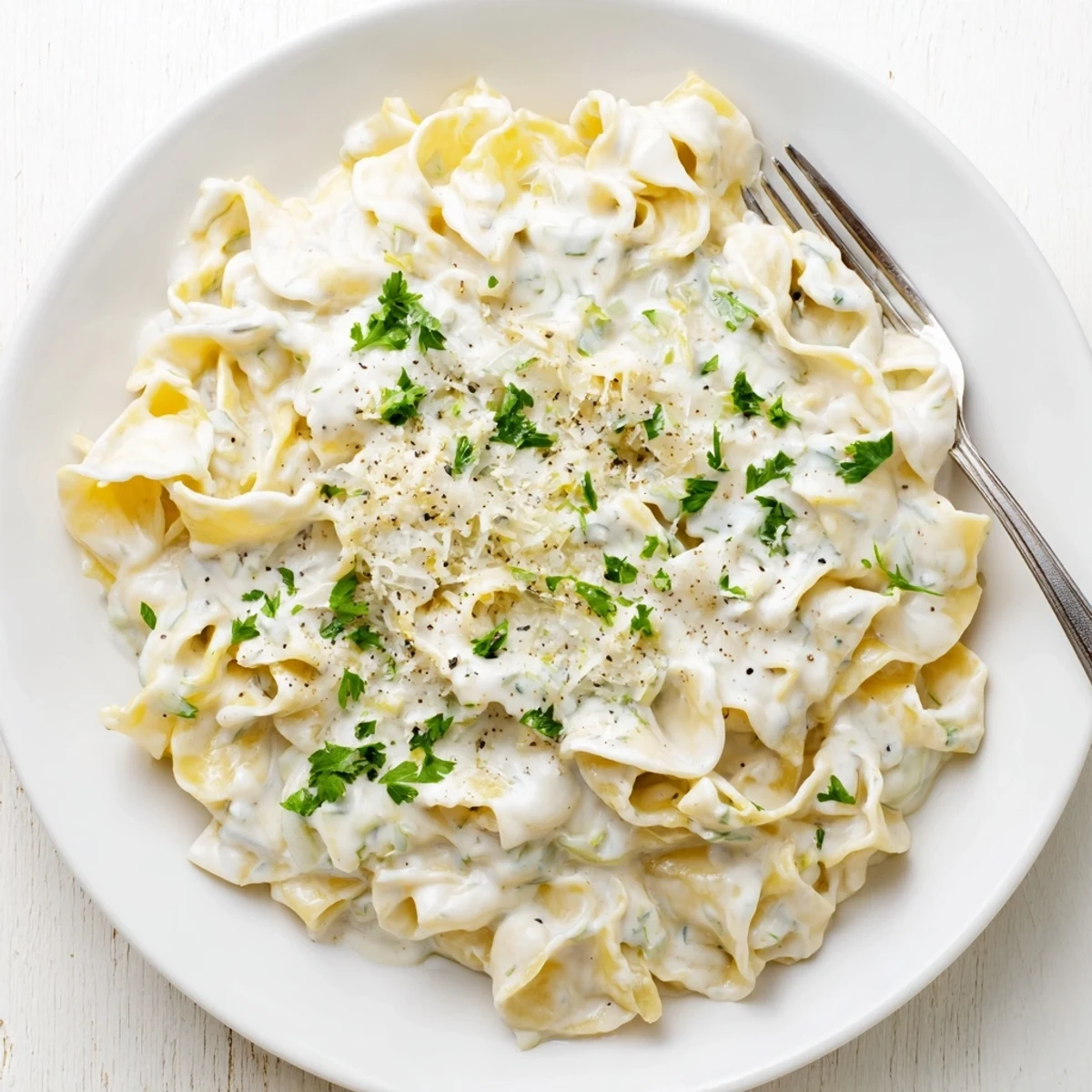 Comforting creamy cafeteria noodles dish garnished with chopped parsley and extra cheese sprinkles.