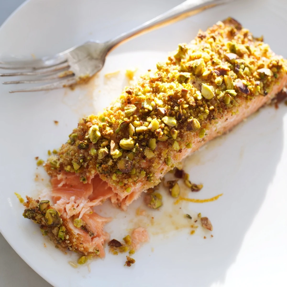 Golden maple pistachio salmon fillet with a crunchy nutty crust on parchment paper