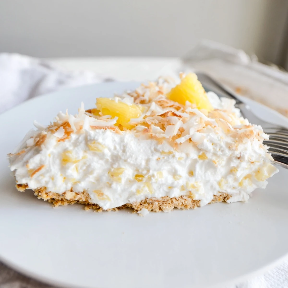 Creamy No Bake Pineapple Coconut Cream Cake layered over a buttery graham cracker crust