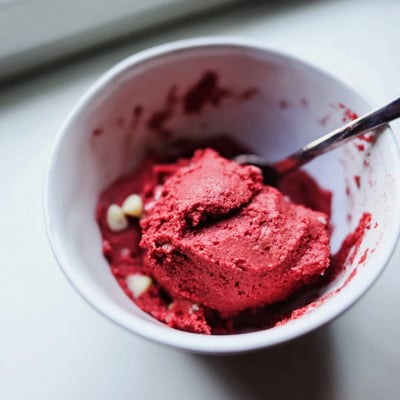 Vibrant red velvet cookie dough swirled with mini chocolate chips in a rustic bowl