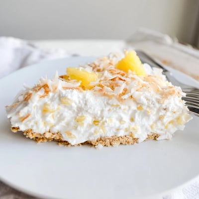 Creamy No Bake Pineapple Coconut Cream Cake layered over a buttery graham cracker crust